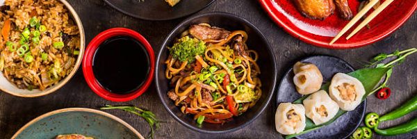 Assorted Chinese food set. Chinese noodles, fried rice, dumplings, peking duck, dim sum, spring rolls. Famous Chinese cuisine dishes on table. Top view. Chinese restaurant concept. Asian style banquet